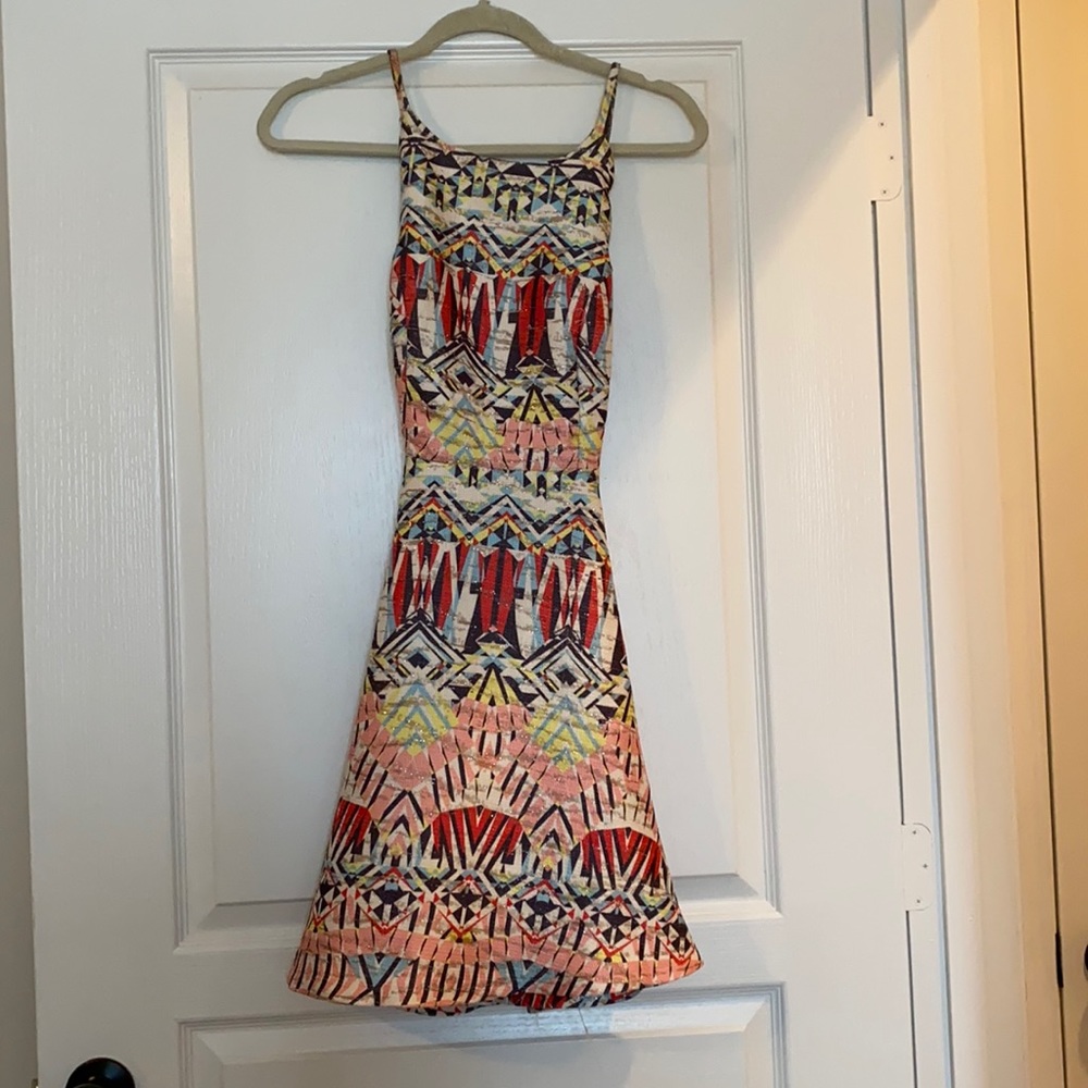 Cute patterned dress with crisscross straps and scalloped edges on the top!